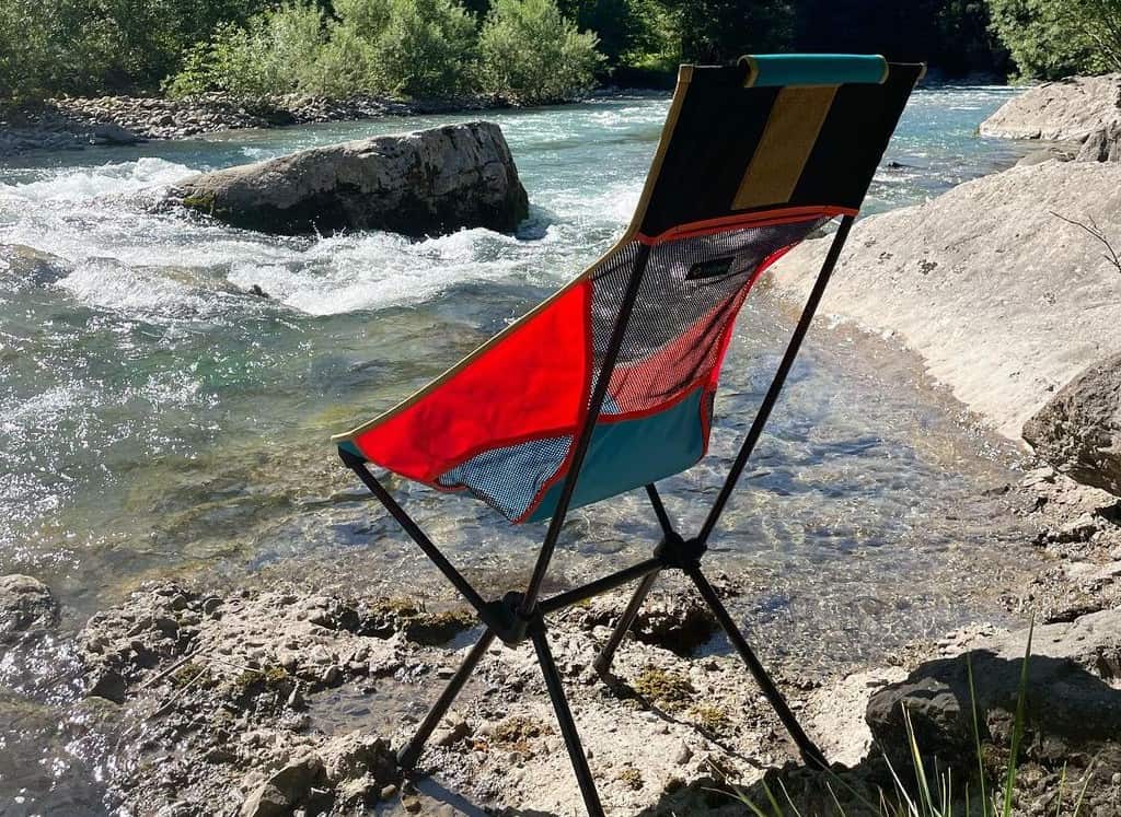 red camping chair on the riverbank