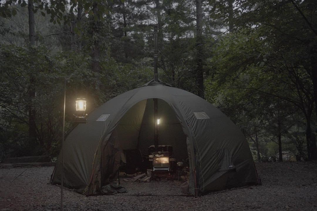 a gray tent and a lamp next to it