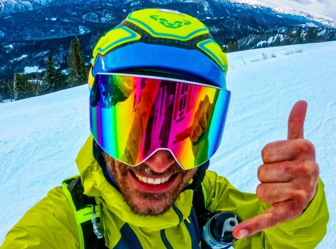 A satisfied skier with brightly colored ski goggles