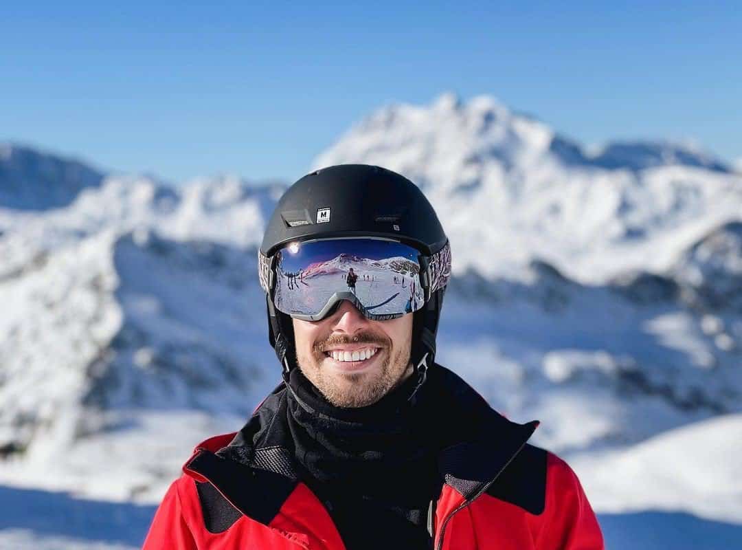 smiling skier in helmet and ski mask 