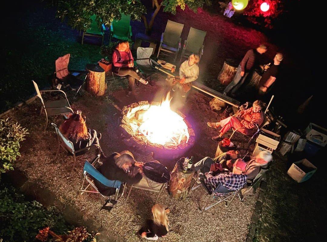 A large company sits around a campfire